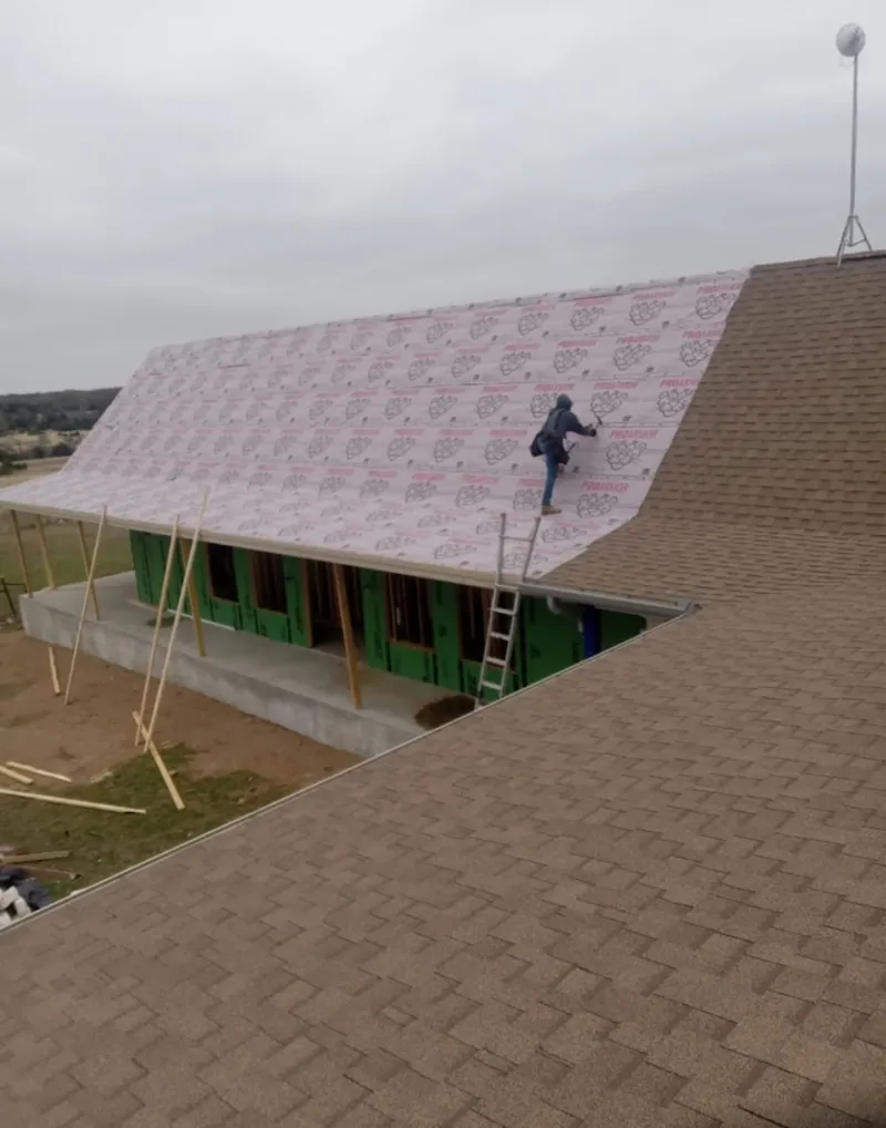 Worker preparing underlayment for a metal roof installation in Strongsville